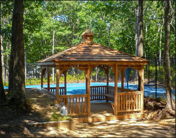 12 x 12 Cedar Rectangular Gazebo shown with red cedar deck, 1x3 standard railings, straight posts, straight fascia, cedar shake shingles, unstained, stainless steel hardware, additional entrance, 8 bench sections and cupola. 