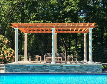 12 x 20 Red Cedar Solace Free Standing Pergola shown with Cedar Stain/Sealer, 16" top runner spacing, straight posts, no deck, customer supplied columns, lattice wall, 9 posts, Veranda Outdoor Ceiling Fan