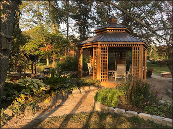 14 Custom Cedar Hexagon Double Roof Gazebo shown with Sandcastle Composite Deck, Custom Lattice Panels, Cupola, and Charcoal Metal Roof.