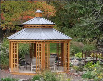 14 Custom Cedar Hexagon Double Roof Gazebo shown with Sandcastle Composite Deck, Custom Lattice Panels, Cupola, and Charcoal Metal Roof.