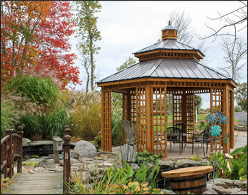 14 Custom Cedar Hexagon Double Roof Gazebo shown with Sandcastle Composite Deck, Custom Lattice Panels, Cupola, and Charcoal Metal Roof.