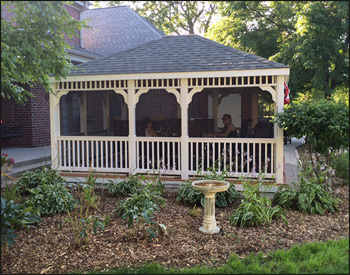  14 x 16 Vinyl Rectangular Gazebo shown with White Vinyl, Teakwood composite deck, 1x1 standard railings, standard braces, top railing section, straight fascia,  full set of screens and screen door, Oxford Gray asphalt shingles, Hidden Wiring w/ 1 Receptacle & Switch.