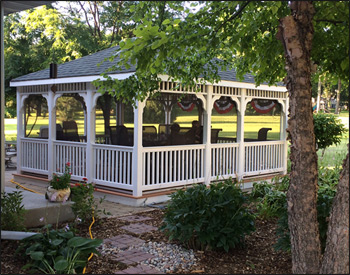  14 x 16 Vinyl Rectangular Gazebo shown with White Vinyl, Teakwood composite deck, 1x1 standard railings, standard braces, top railing section, straight fascia,  full set of screens and screen door, Oxford Gray asphalt shingles, Hidden Wiring w/ 1 Receptacle & Switch.